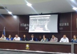 Pessoas sentadas à mesa de honra do Plenário da Câmara Municipal de Teresina