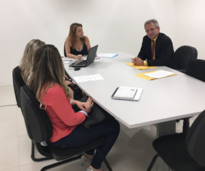 Quatro pessoas em torno de uma mesa de reuniões.
