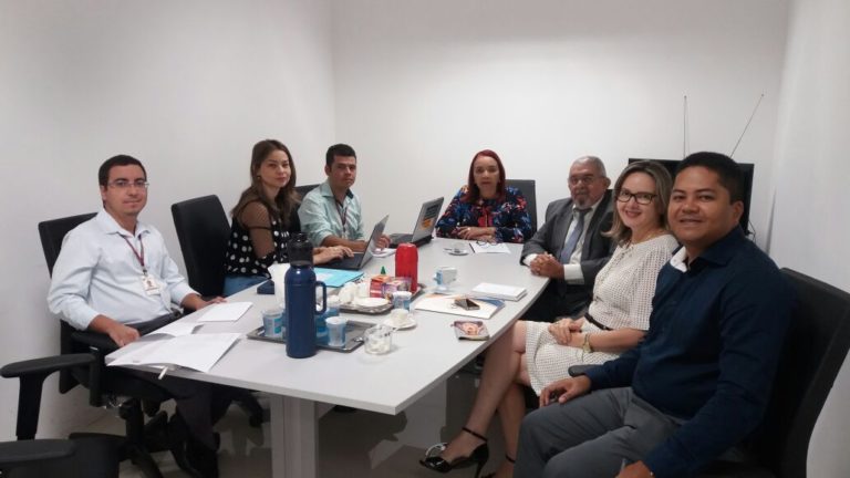 Pessoas reunidas em torno de uma mesa redonda