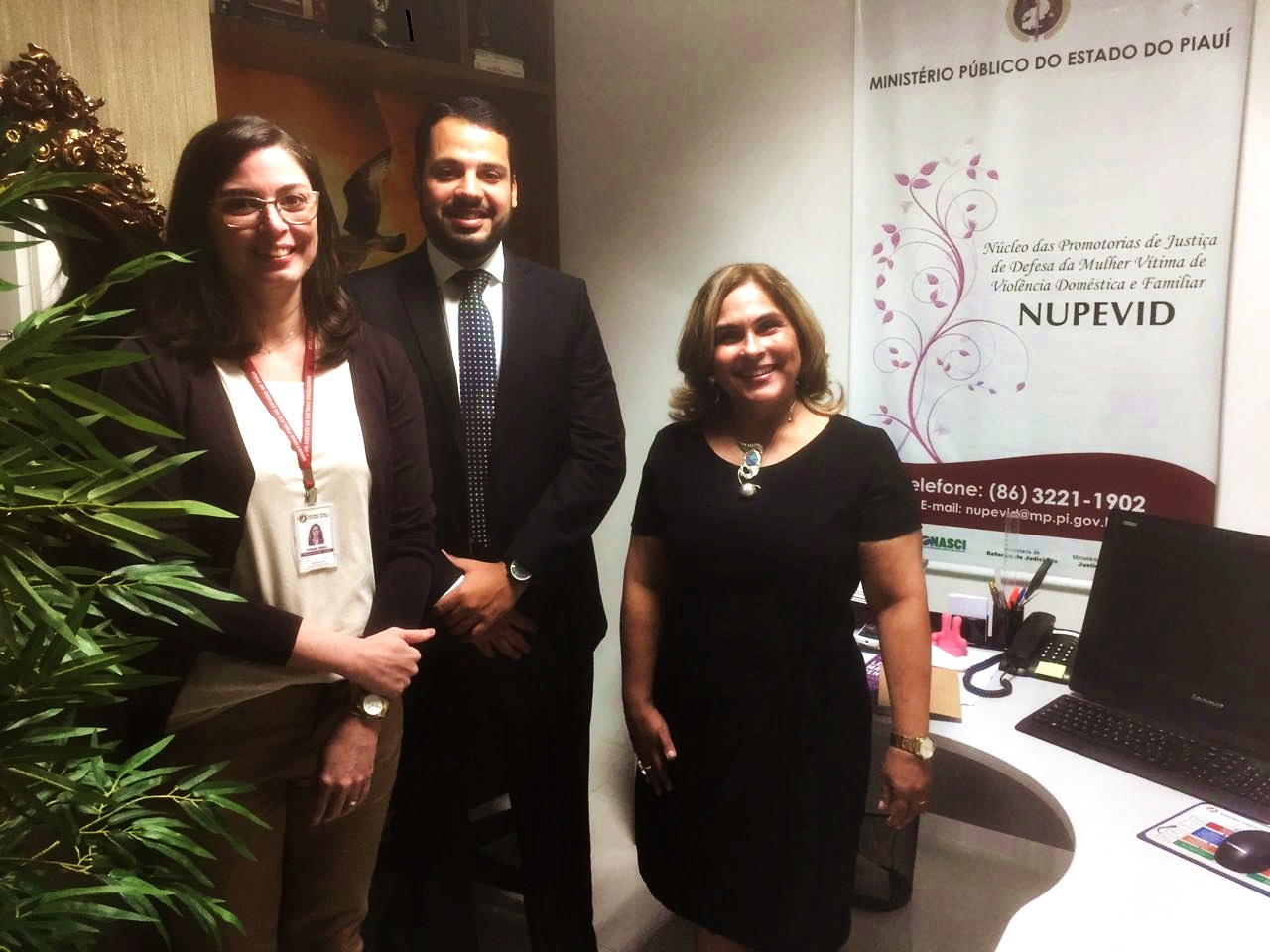 Promotora de Justiça e servidora do Nupevid com representante do Prêmio Innovare, posando de pé