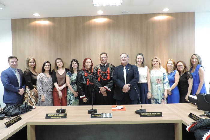 Grupo de pessoas posa de pé, com o Procurador-Geral de Justiça trajado com beca