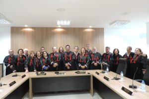 Colégio de Procuradores de Justiça posa de pé. Cerca de vinte pessoas trajando becas