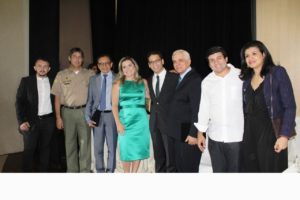 Pessoas de pé abraçadas sorrindo para fotografia