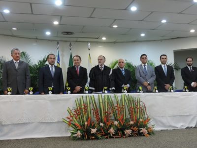 Pessoas de pé atrás de uma mesa, com arranjos de flores