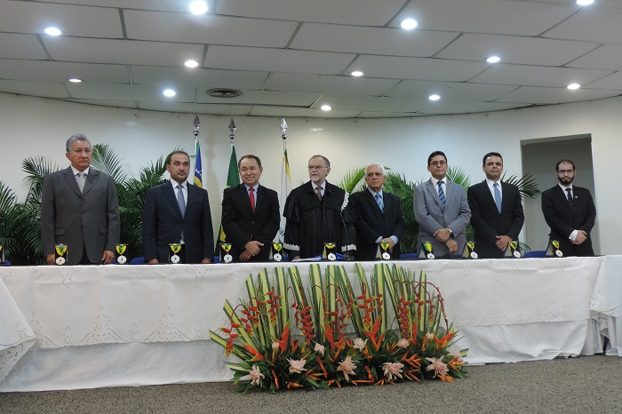 Pessoas de pé atrás de uma mesa, com arranjos de flores