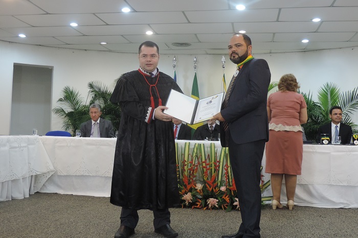 Duas pessoas segurando um livro com as mãos