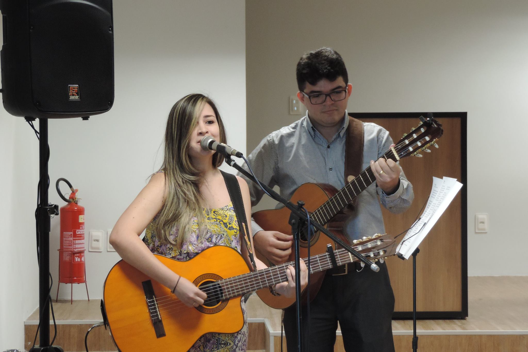Duas pessoas segurando instrumentos musicais enquanto cantam