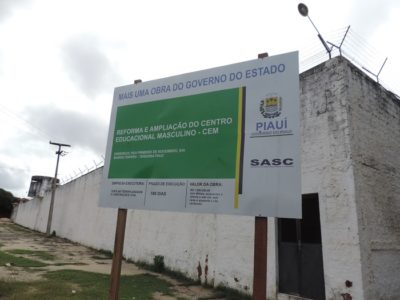 Foto da fachada de um prédio com placa com informações sobre a obra