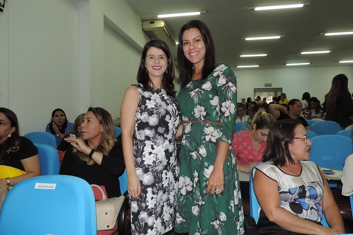 Duas mulheres olhando para fotografia e sorrindo 