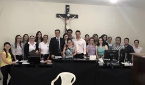 Pessoas de pé atrás de uma bancada sorrindo para fotografia