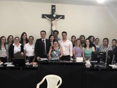 Pessoas de pé atrás de uma bancada sorrindo para fotografia