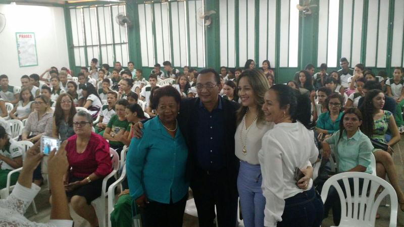 Pessoas sentadas, enquanto quanto pessoas estão pé sorrindo para fotografia 
