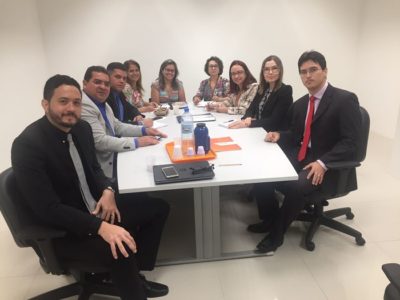 Pessoas sentadas em volta de uma mesa olhando para fotografia