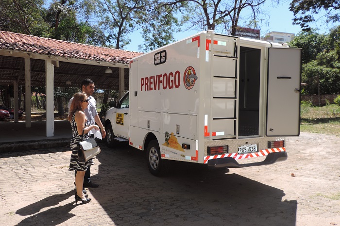 Duas pessoas de pé olhando para um carro 