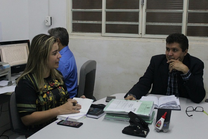 Duas pessoas sentadas em volta de uma mesa, olhando um para o outro enquanto conversam 