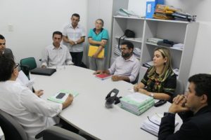 Pessoas sentadas em volta de uma mesa conversando
