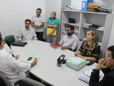 Pessoas sentadas em volta de uma mesa conversando