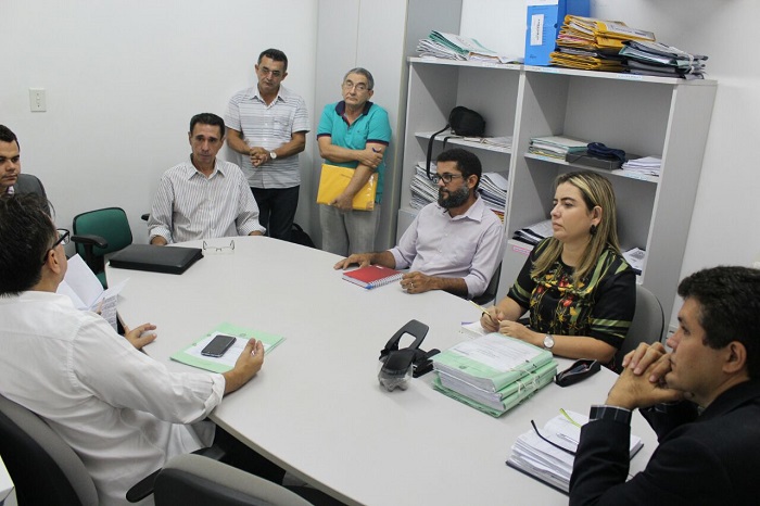 Pessoas sentadas em volta de uma mesa conversando