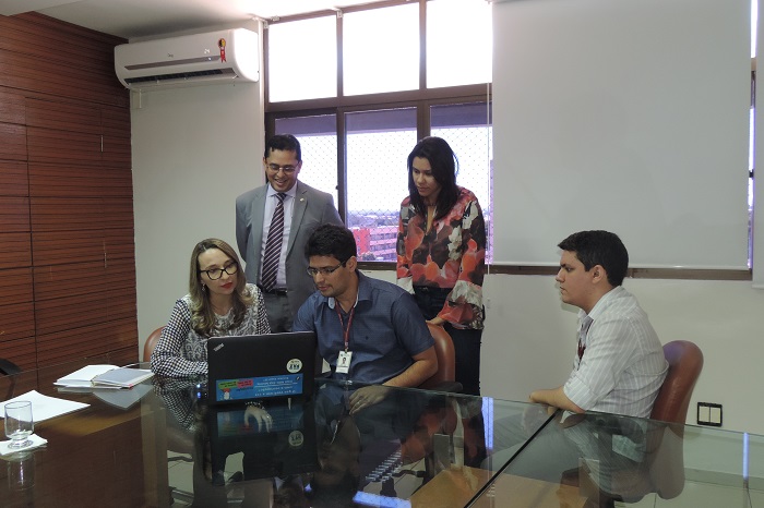 Pessoas de pé olhando para o computador