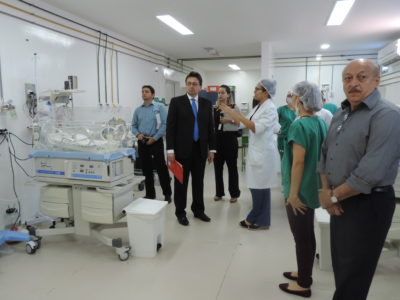 Pessoas de pé dentro de uma UTI, as pessoas conversam enquanto olham os equipamentos hospitalares
