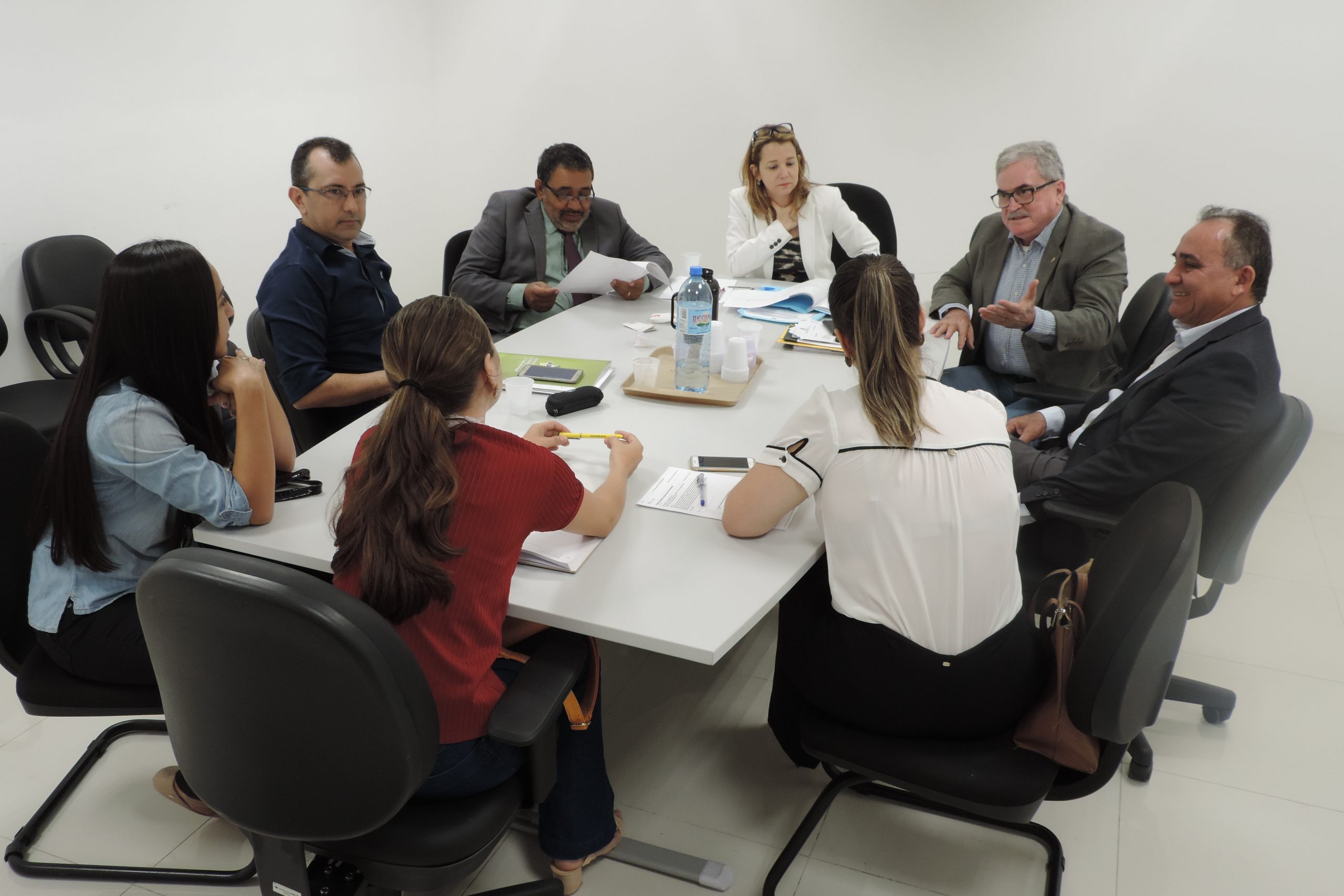 Pessoas sentadas em torno de uma mesa conversando uns com os outros 