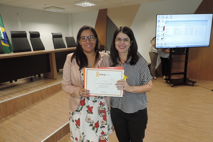 Duas pessoas de pé segurando um certificado 