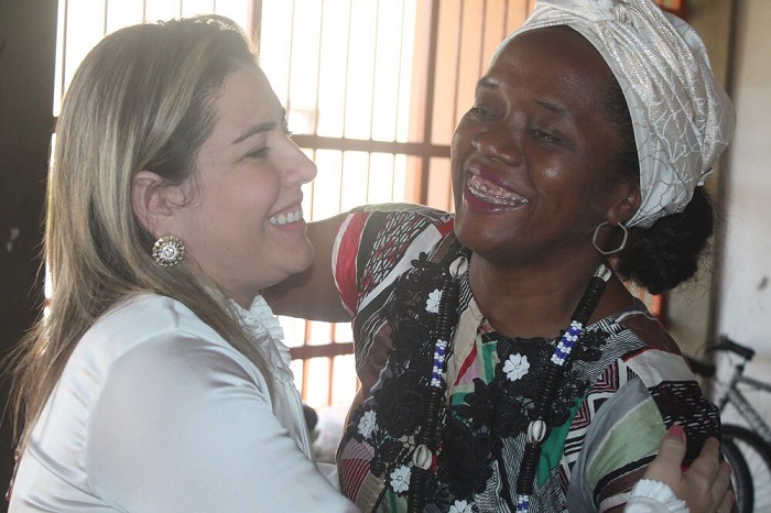 Duas pessoas sorriem e se abraçam 