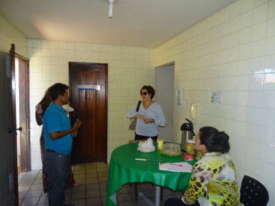 Pessoas de pé dentro de uma cozinha conversando