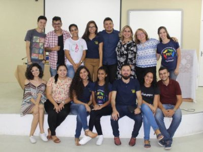 Pessoas de pé e sentadas olhando para fotografia
