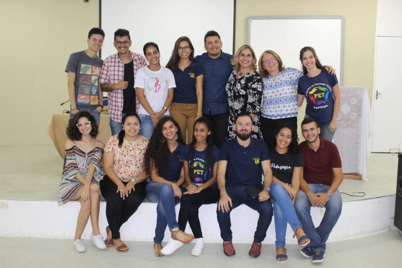 Pessoas de pé e sentadas olhando para fotografia 