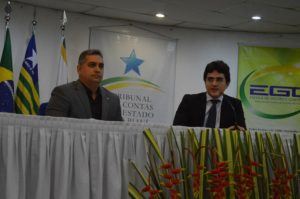 Dois homens sentados atrás de uma mesa