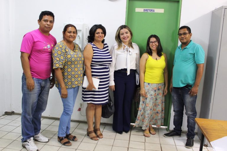 Pessoas de pé olhando para o fotógrafo que está logo a frente