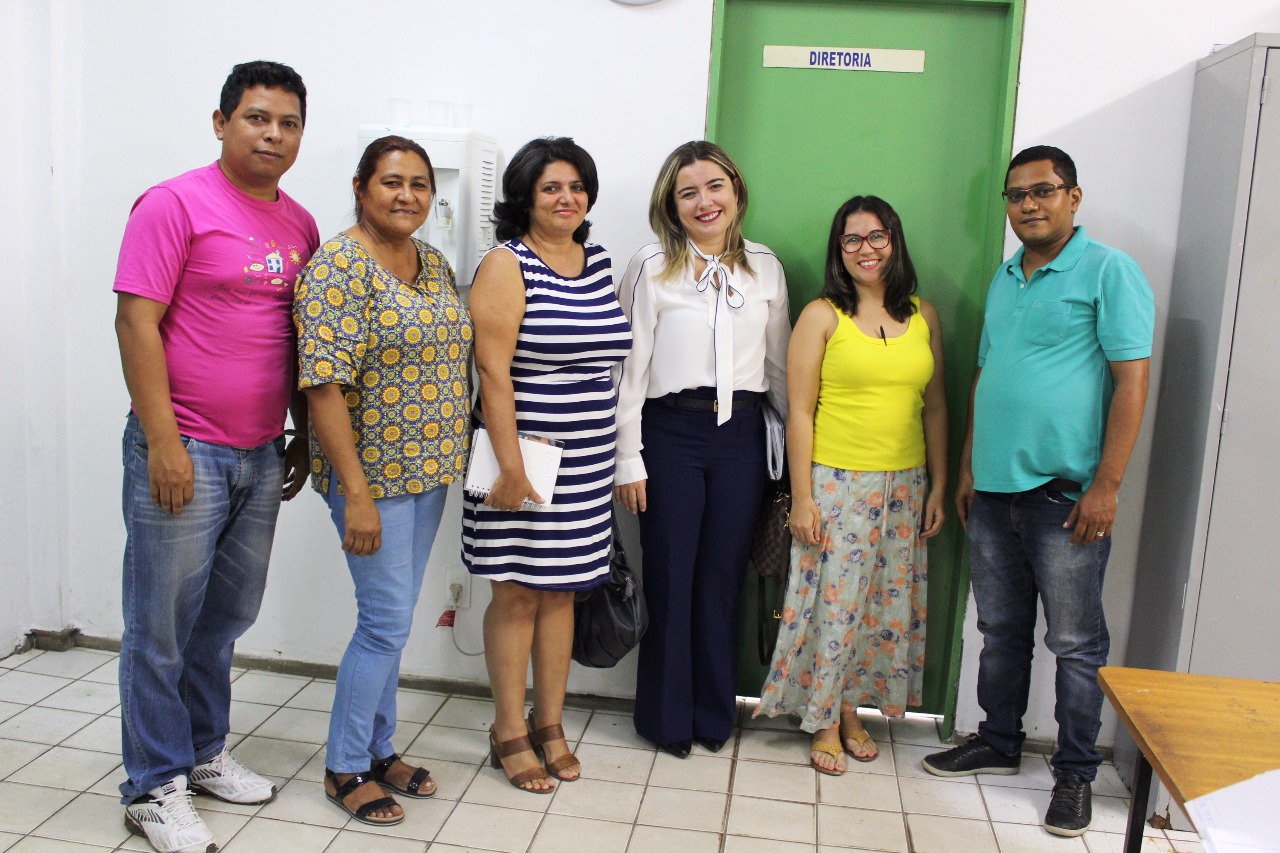 Pessoas de pé olhando para o fotógrafo que está logo a frente 