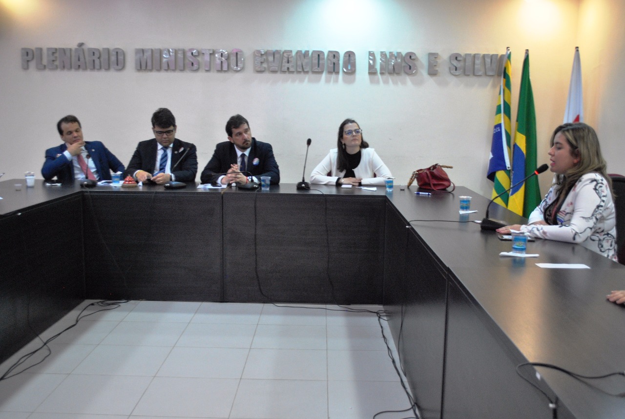 Pessoas reunidas em torno de uma mesa em U.