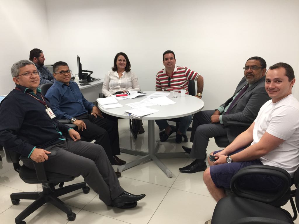 Pessoas reunidas em torno de uma mesa de reuniões.