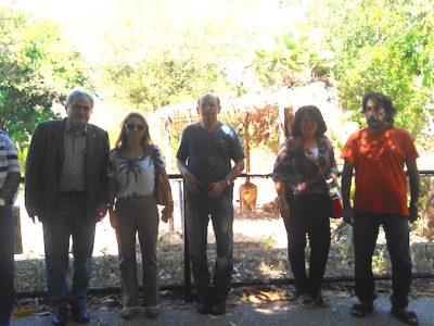 Equipe de inspeção posa em frente à célula em que está alojado um casal de leões.