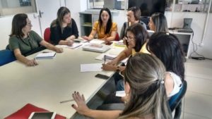 Pessoas sentadas em volta de uma mesa
