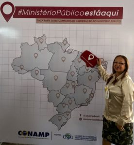 Mulher de pé apontando para o Piauí no mapa do Brasil