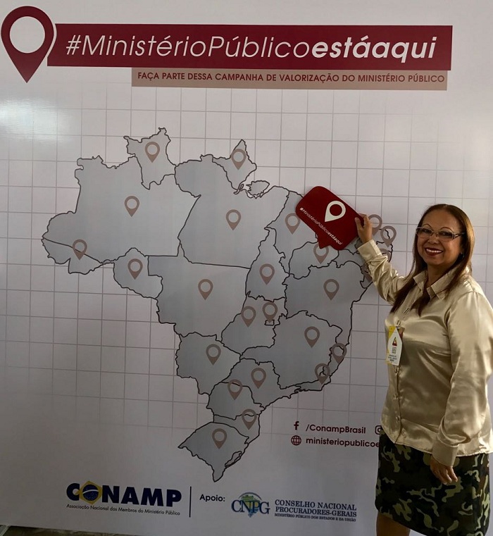 Mulher de pé apontando para o Piauí no mapa do Brasil