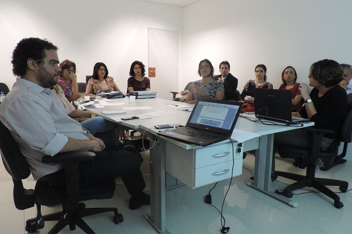 Pessoas sentadas em volta de uma mesa 