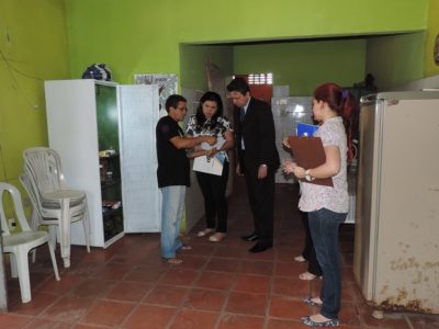 Pessoas de pé olhando um papel e conversando