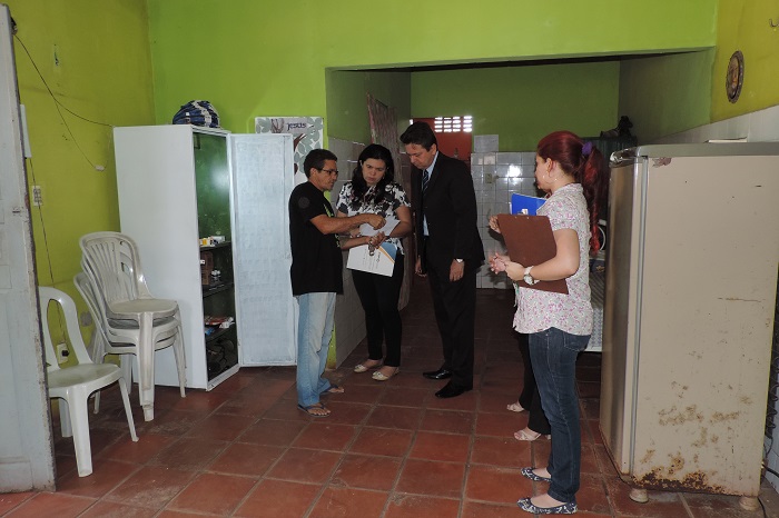 Pessoas de pé olhando um papel e conversando