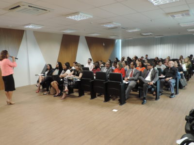 Pessoas sentadas olhando um mulher que está de pé