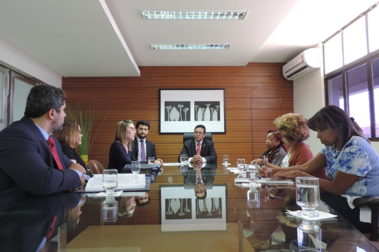 Pessoas sentadas em volta de uma mesa