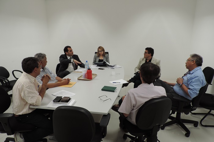 Pessoas sentadas em volta de uma mesa conversando