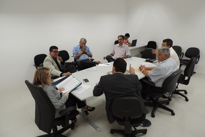 Pessoas sentadas em volta de uma mesa conversando