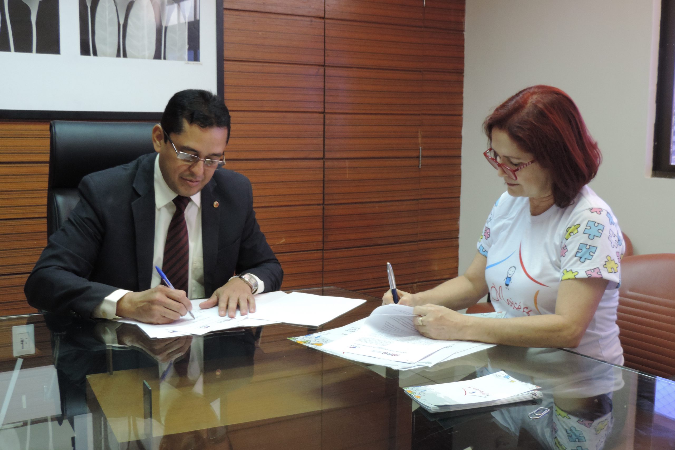 Duas pessoas assinando um documento