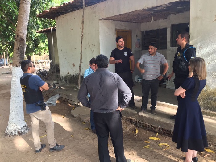Pessoas de pé em área externa de uma casa conversando em uma roda