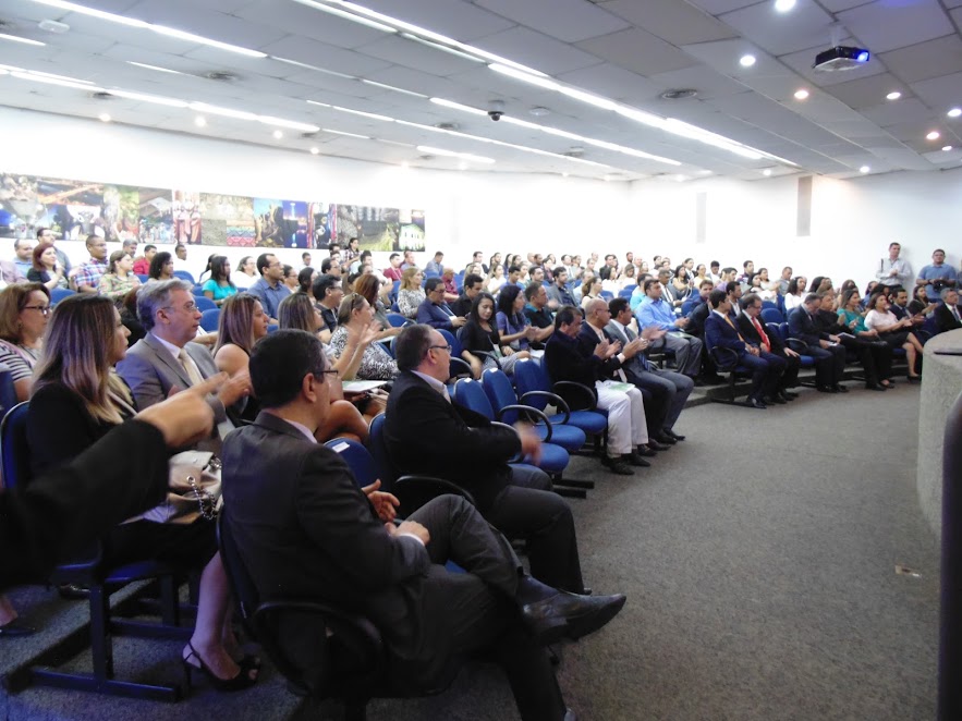 Pessoas sentadas em um auditório assistindo palestra