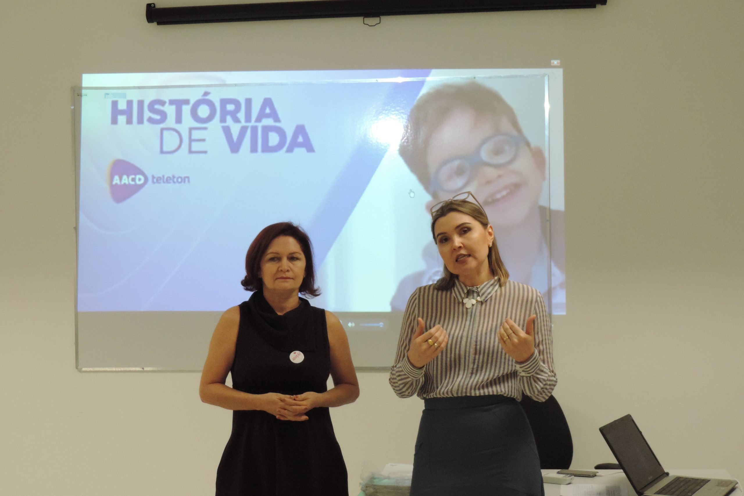Pessoas sentadas em uma sala assistindo palestra